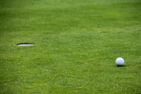 Golf ball on lip of cup 写真素材