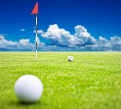 Golf ball on a putting green with  the flag in the background - very shallow  Stock Illustration