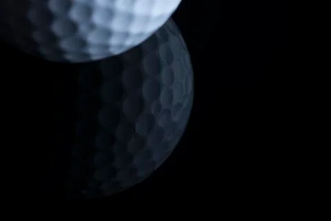 Golf ball with reflection isolated on black background. Stock Photos