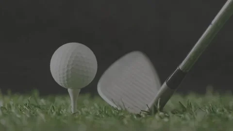 Golf ball remaining on tee while approaching iron starting swing, hitting turf Stock Footage 333911602