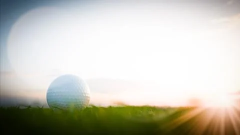 Golf ball resting on grass at sunset on golf course Stockillustratie