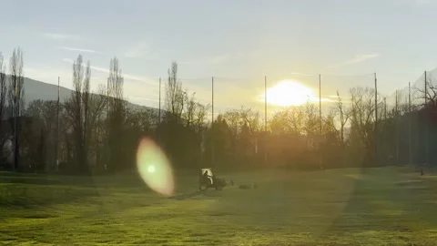 Golf Ball Retrieval Machine at Driving Range with Sunlight and Lens Flare Stock Footage 224887689
