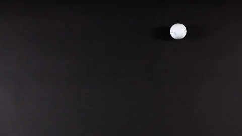 Golf Ball Rolling on Black Surface Stock Footage 309598922