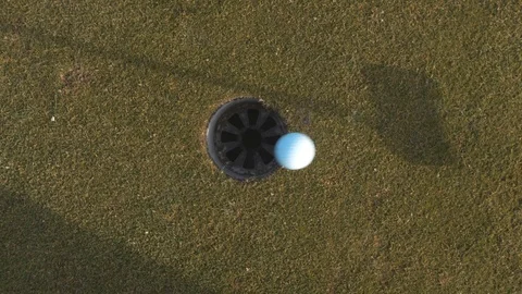 Golf ball rolling into hole Stock Footage 104564058