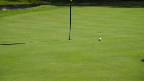 Golf ball rolls past the flag in the hole 库存影片 155363396