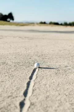 Golf ball in sand bunker Stock Photos