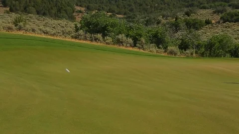 Golf ball slow motion hit onto fairway and rolls across putting green golf c Video stock 125331959
