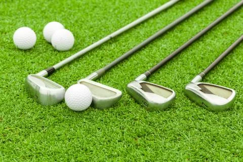 Golf ball on tee in front of driver on green course Stock Photos