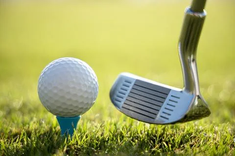 Golf ball on tee in front of driver Stock Photos