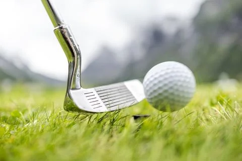 Golf ball on tee in front of driver Stock Photos