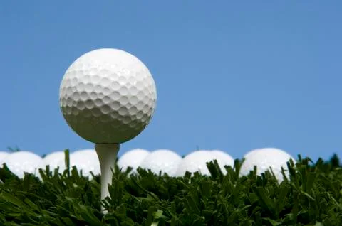Golf ball on tee on grass Stock Photos