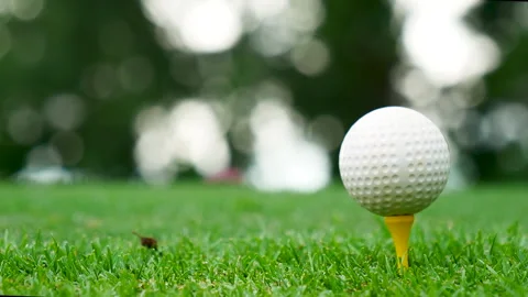 Golf ball on tee in green golf field with recreation sport training course Видео 265050069