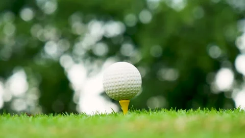 Golf ball on tee in green golf field with recreation sport training course Видео 265050257