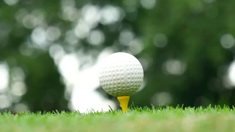 Golf ball on tee in green golf field with recreation sport training course Видео 265050269