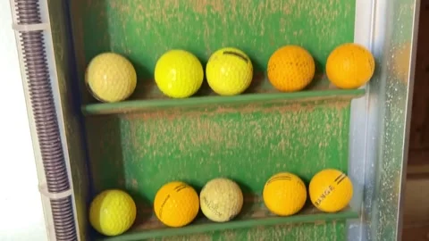 Golf balls moving through automatic collection machine at driving range Stock Footage 341710281