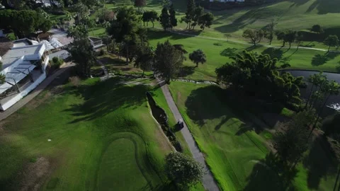 Golf cart drives through the courses view from a drone Stock Footage 232241064