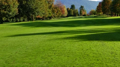 Golf Course with Autumn Trees and Mountain View in a Sunny Day 動画素材 220477405