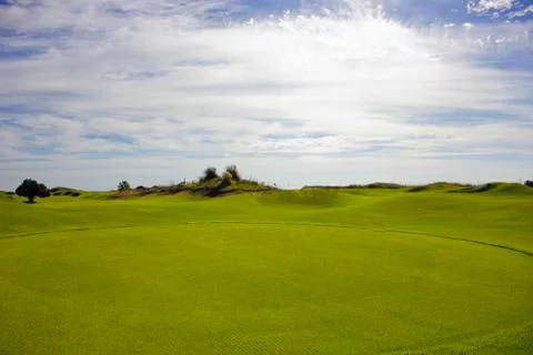Golf course in Belek. Green grass on the field. Blue sky, sunny day Stock Photos