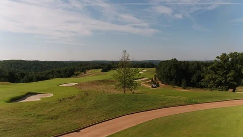 Golf course drone shot down fairway with tree foreground movement Video stock 93379778
