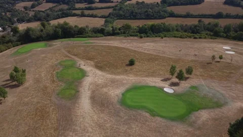 Golf course fairway with green putting green and water reservoir pond, aerial Vidéo 343783291