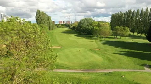 Golf course, green with flag marking hole and footbridge over brook Stock-Footage 155814584