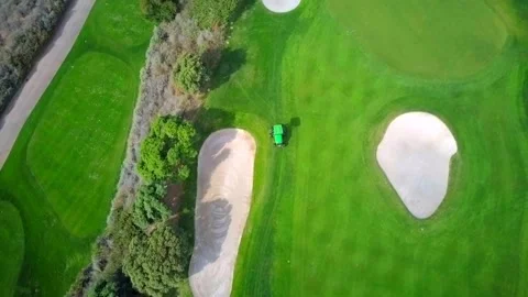 Golf Course Maintenance: Tractor Mowing Green with Sand Bunkers Stock-Footage 339267368