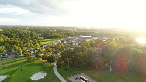 Golf course rise aerial shot to sunset Stock Footage
