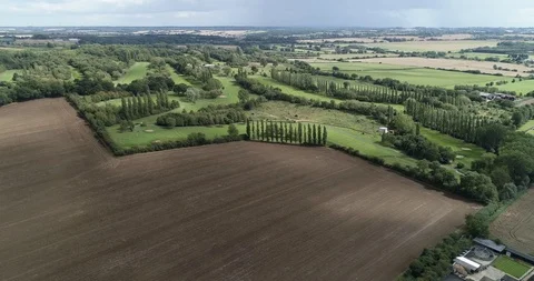 Golf course with trees and long greens next to brown farmland drone aerial 4k Stock Footage 125752823