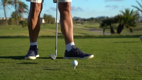 Golf course turf. Hands of an older man place a tee and golf ball on the gr.. Stock Footage 252603880
