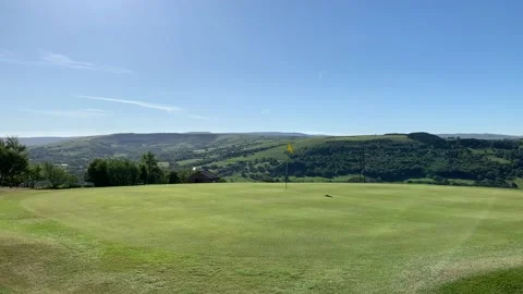 Golf course view with blue sky and views across to mountains and countryside. Stock Footage 136819380
