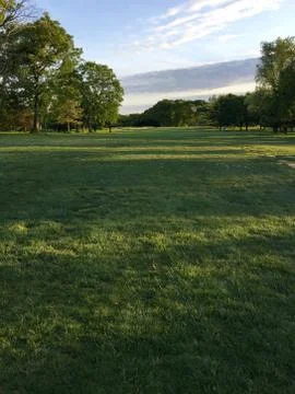 Golf course view down the fairway at sunset. Stock Photos