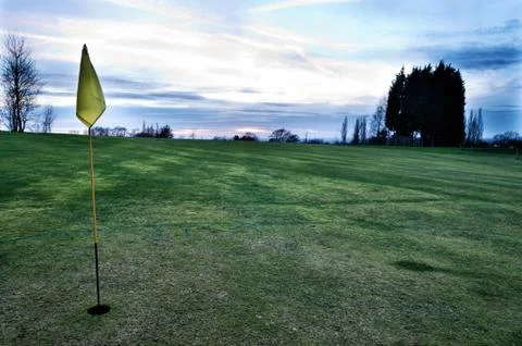 Golf course with yellow flag Stock Photos