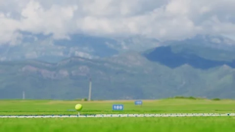 Golf driver strikes neon ball on range with clouded Adriatic peaks Stockbeeldmateriaal 329413128
