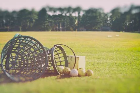 Golf at the driving range Basket with golf balls at the rough zone of course Stock Photos