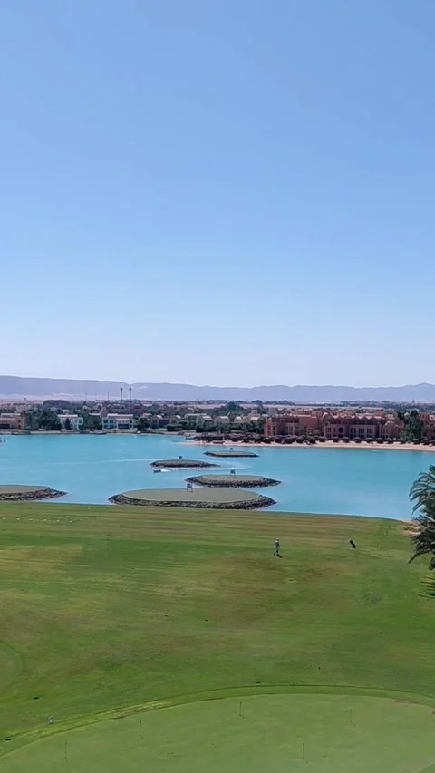 Golf driving range green fairway with aqua lagoon view in El Gouna Egypt. Stock Footage 340106060