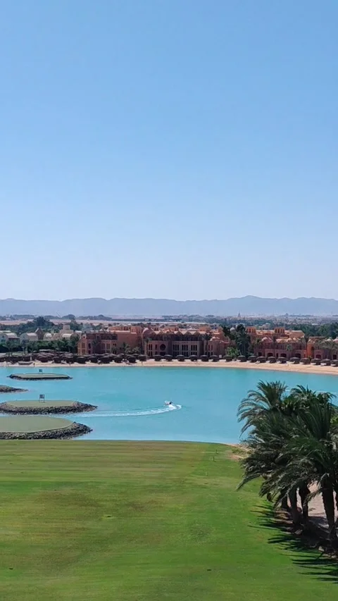 Golf field with palm trees aqua lagoon and boat in El Gouna Egypt. Stock Footage 340106811