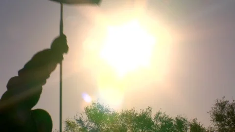 Golf flag silhouette in front of sun golfer caddy Stock Footage 125278136