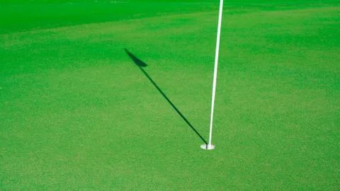 Golf hole with the shadow of the flag Stock Photos