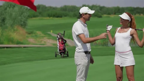 Golf instructor passionately explains the game to a charming woman Stock Footage 311644168