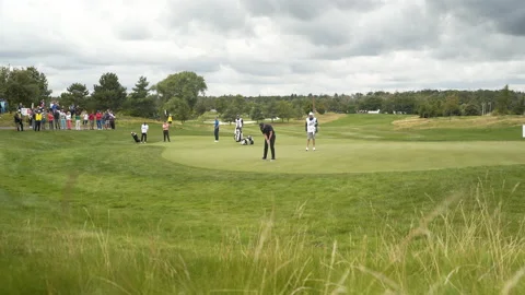 Golf player doing a final shot at a tournament on a golf course green. Stock Footage 169372643