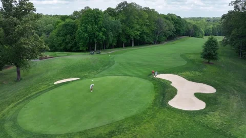 Golf Player golfing and putting ball into hole on golf course. American city Stock Footage 309752237