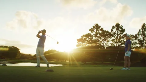 Golf Player hitting the Golf Ball while the other one is watching Stock Footage 264153442