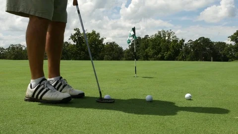 Golf player puts in 3 balls; sliding dolly shot Stock Footage 84117094