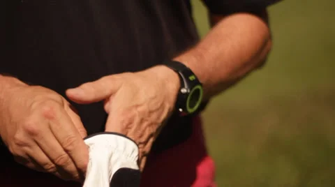 Golf player putting on glove Stock Footage 27798984