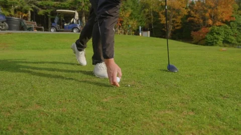 Golf Player Setting Up the White Tee on the Green Golf Course 4K Stock Footage 300468456