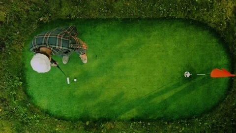 Golf player is successfully hitting the ball in top view. Golfer in a plaid Stock Footage 117046210