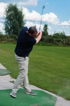 Golf player at tee off on a golf course Stock Photos