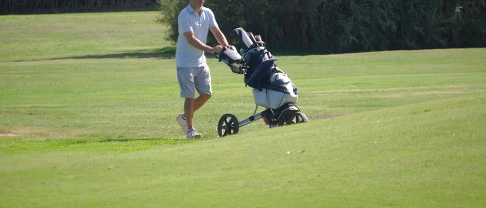 Golf player walking on the course Stock Photos