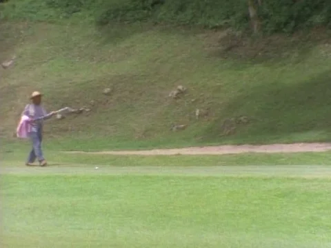 Golf players walking around the golf course with golf clubs on a sunny day Stock Footage 79877143
