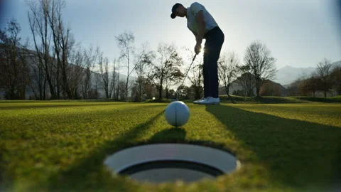 Golf putt dropping into hole on green in Sion Switzerland Stock Footage 332032102